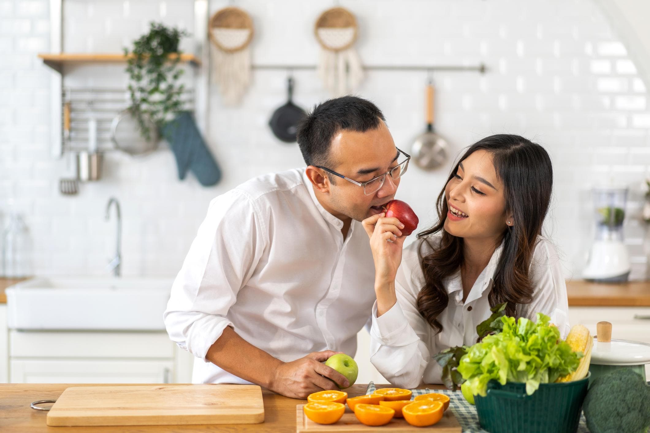 Couple sharing an apple together in their kitchen