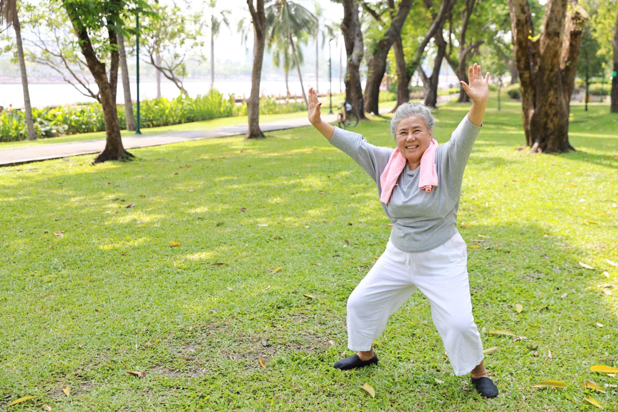 Older woman stretching and exercising outdoors in a park